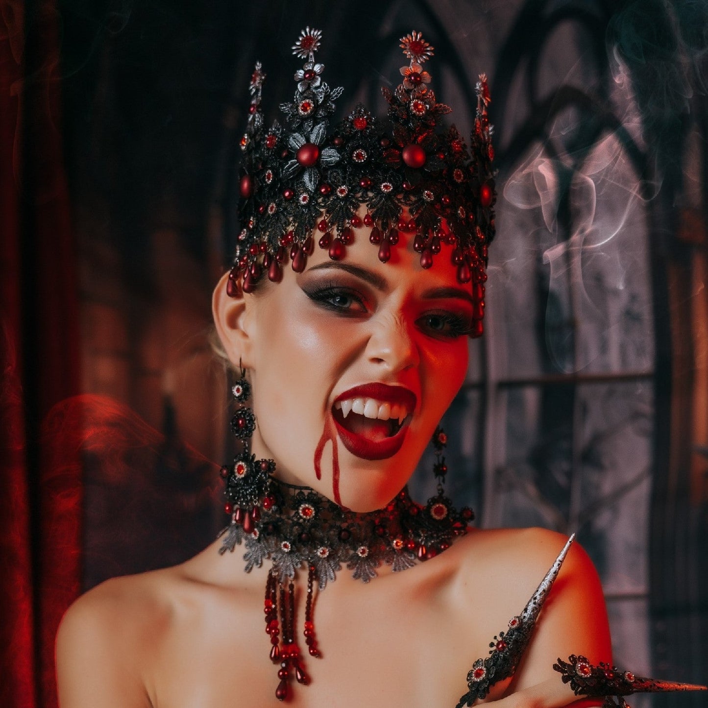 Dark Vampire Queen wearing a gothic crown with blood-red jewels, statement jewellery and elegant Halloween makeup