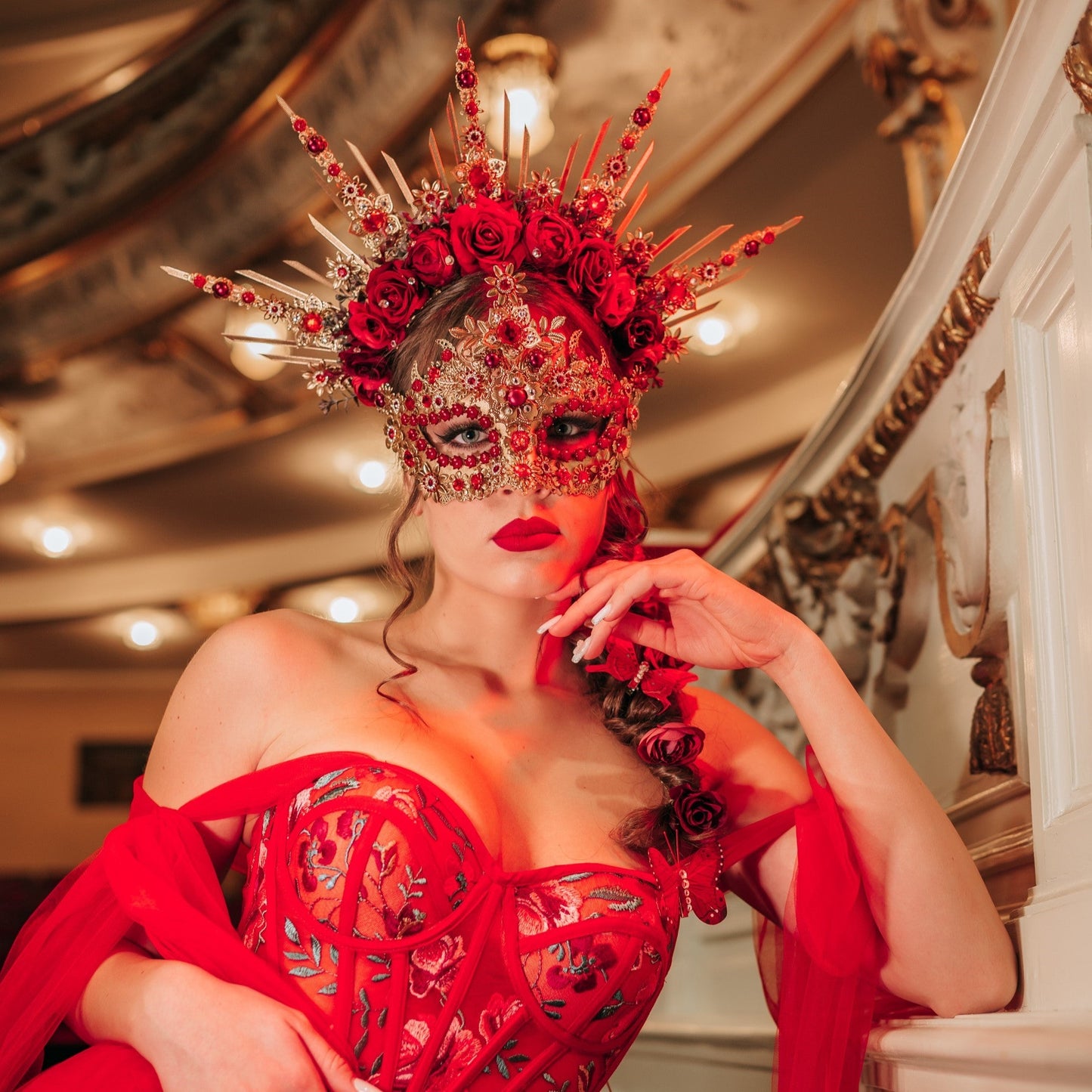 Red fantasy masquerade couple wearing handcrafted masks and statement crowns for an unforgettable luxury masquerade ball experience.