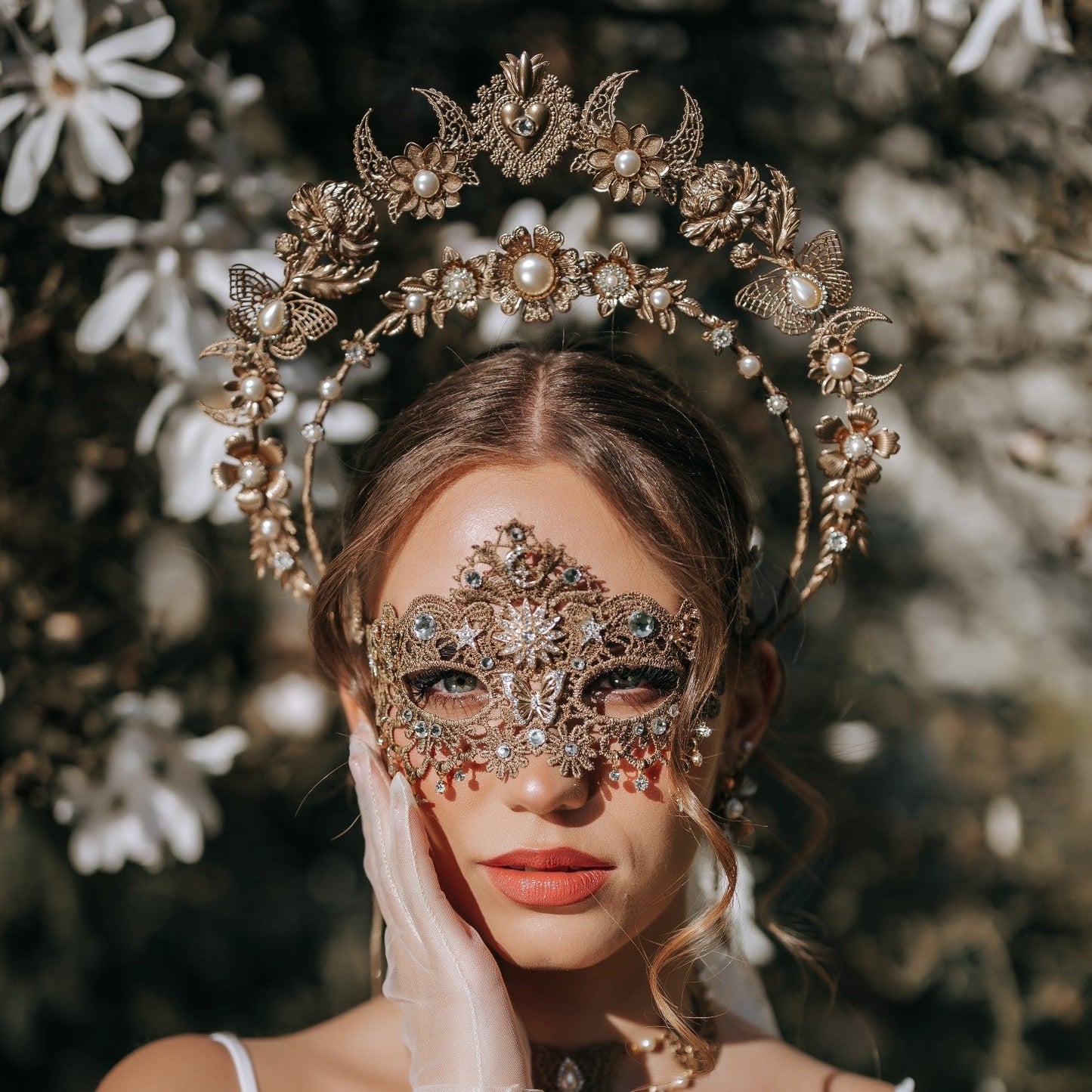 Luxury gold masquerade headdress with celestial halo crown and ornate bridal mask designed for statement wedding styling.