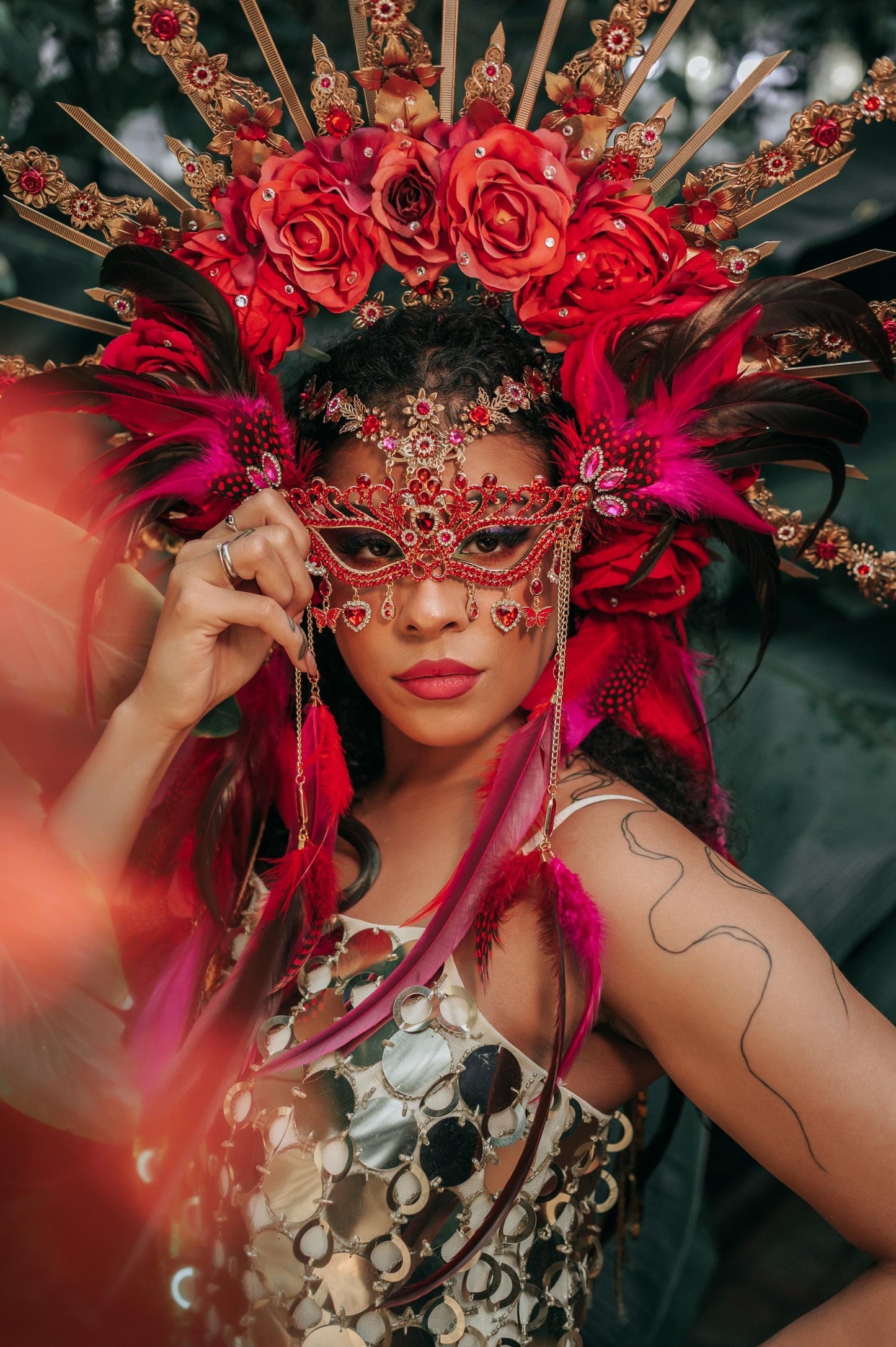 red masquerade dresses with mask Portrait of woman in red gown and red masquerade mask holding red rose Stock Photo