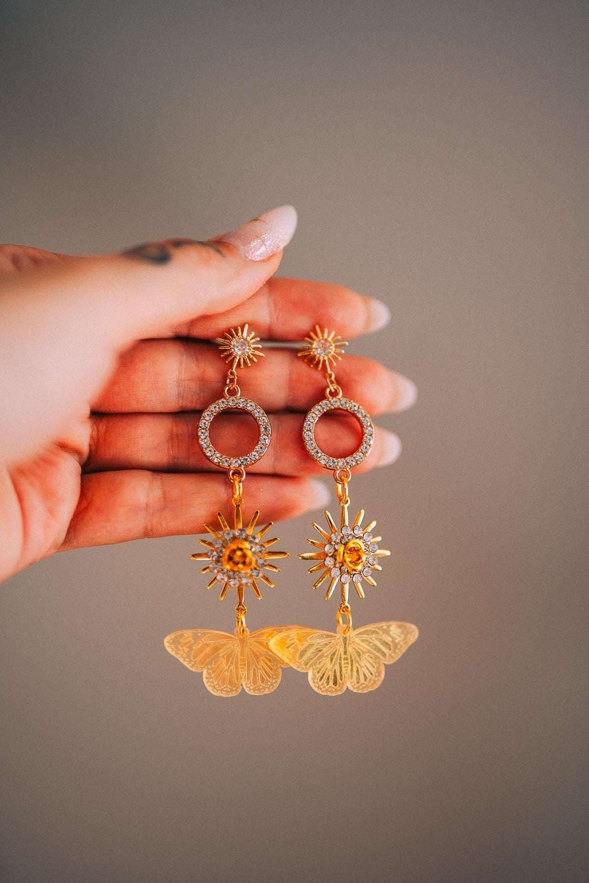 Gold Sun Drop Earrings with Crystal Butterfly Details – Celestial Statement Jewelry